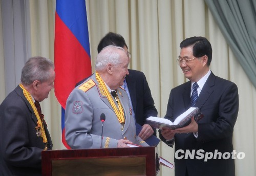 俄羅斯老戰(zhàn)士佩戴著獎?wù)拢岩槐緯鳛槎Y物送給胡錦濤。中新社發(fā)張朔攝